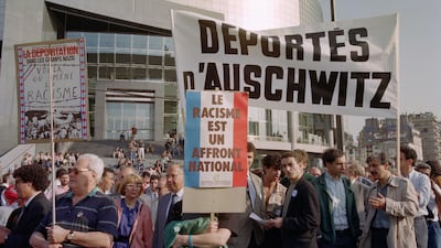 Demonstrators holding a Deportees from Auschwitz banner protest against the National Front and its president Jean-Marie Le Pen on May 9, 1990, at a gathering of the Movement Against Racism and for Friendship between People, near the Opera Bastille in Paris. AFP