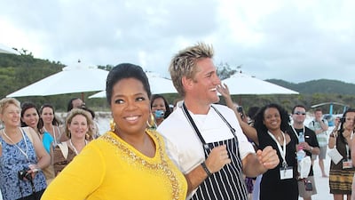 Oprah Winfrey wears a yellow top and beige capris to dance with Chef Curtis Stone on Hamilton Island, Australia on December 8, 2010. Getty Images