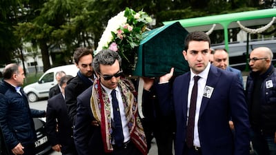 Sinan Urfali, left, the husband of Burcu Gundogar Urfali, carries his wife's coffin. AFP