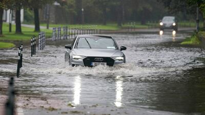 A driver navigates floodwater in Cork, Ireland. PA