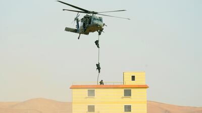 Soldiers descend from a helicopter to enter a building occupied by "terrorists" during one of the military exercises on Saturday. Wam
