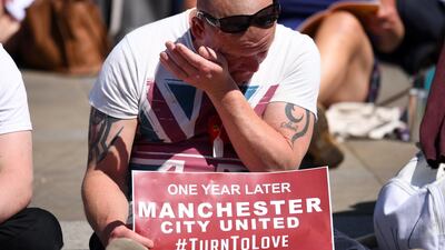 A man wipes tears away as he watches the Manchester Arena National Service of Commemoration outside the city's cathedral. Leon Neal/Getty Images
