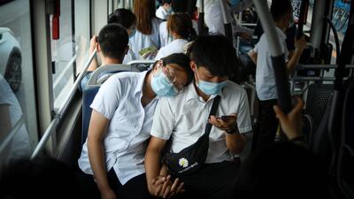 A couple wearing face mask ride on a bus during rush hour in Beijing. China reported 12 new cases of Covid-19 on June 24, including seven domestic cases in Beijing. AFP