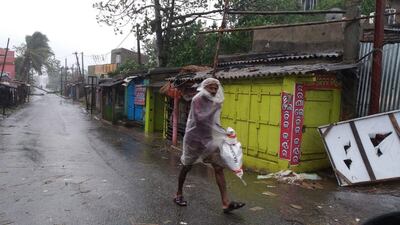 An Indian man walks as wind starts blowing stonger near Dhamra coast at Choudhury Ghat area in the Bhadrak district of Odisha, India. EPA