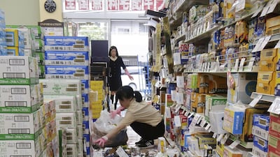Employees try to remove bottles and cans of beverages which are scattered by an earthquake at a liquor shop in Hirakata, Osaka. Reuters