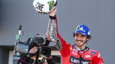 Ducati Lenovo Team rider Francesco Bagnaia celebrates on the podium with a helmet of Italian rider Valentino Rossi, after winning the Valencia GP. AFP