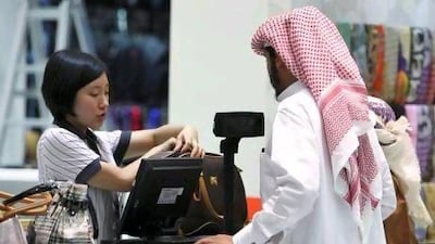 A saleswoman attends to a customer at the cash counter inside a shop at Dragon Mart in Dubai, March 2, 2011. Built in the shape of a dragon, the 1.2 km long and 150,000 sqm large mall is a trading centre with almost 3,950 shops selling mainly Chinese products ranging from office appliances to garments and daily products. Picture taken March 2, 2011. REUTERS/Jumana El Heloueh (UNITED ARAB EMIRATES - Tags: BUSINESS) *** Local Caption *** DUB03_DUBAI-_0303_11.JPG