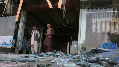 Afghans stand near a damaged shop after an explosion in Kabul, Afghanistan, Wednesday, Aug. 7, 2019. A suicide car bomber targeted the police headquarters in a minority Shiite neighborhood in western Kabul on Wednesday, setting off a huge explosion that wounded dozens of people, Afghan officials said. The Taliban claimed responsibility for the bombing. (AP Photo/Rafiq Maqbool)
