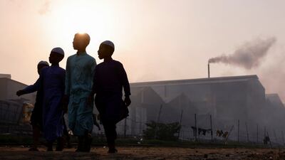 Children pass a re-rolling mill in Dhaka, Bangladesh. Reuters