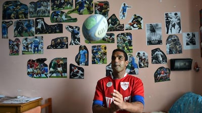 A 'La Drola' player tosses a rugby ball in his cell prior to a match at Lorusso e Cutugno penitentiary. Gabriel Bouys / AFP