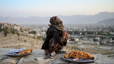 A samosa vendor watches kites being flown on Nadir Khan Hill overlooking Kabul, Afghanistan. AFP