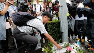 A man places flowers near the torched building. Reuters