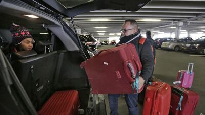 Dima, 7, watches her father Munther Alaskry load their luggage in a car at New York’s JFK International Airport on Febuary 3, 2017. The Iraqi family arrived in New York after the Trump administration reversed course and said Mr Alaskry and other interpreters who supported the US military could come to America. Richard Drew / AP Photo