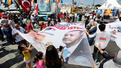 In this photo taken on Wednesday, June 20, 2018, people wave a banner with a picture of Turkish President Recep Tayyip Erdogan, during a gathering of supporters of his ruling Justice and Development Party (AKP) in Istanbul. Lefteris Pitarakis / AP Photo
