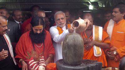 India's prime minister Narendra Modi pours holy water on a lingam or shivling, a representation of the Hindu deity Shiva used for worship, during a Hindu religious ceremony on the second day of his visit to the Republic of Mauritius. George Michel/AP Photo