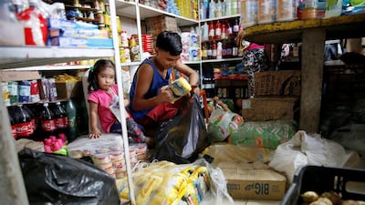 A boy puts packets of corn flour made in Colombia in a plastic bag at a market in La Fria. Carlos Garcia Rawlins/Reuters