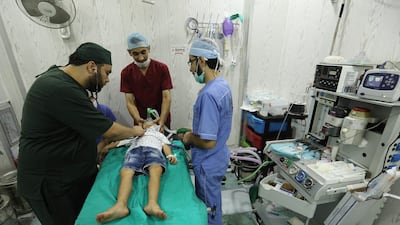 Syrian doctors treat to a boy at a hospital in Idlib province / AFP