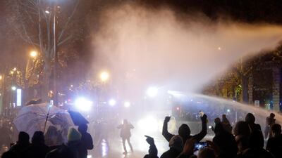 French police use a water cannon as they face off with demonstrators at the Place de la Republique in central Paris. Reuters