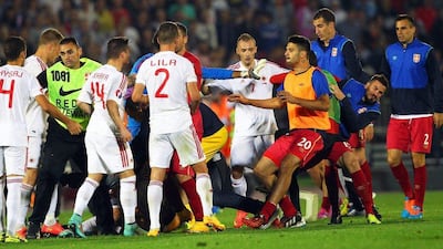 The Albanian national football team, in white, and Serbian national football team, in red, begin to brawl following the flag incident inside Belgrade's Partizan Stadium on Tuesday night. Koca Sulejmanovic / EPA