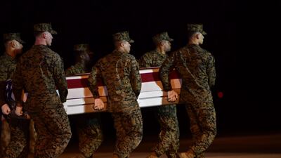 Military personnel carry a transfer case for Sgt Diego Pongo, one of two US Marines killed during a raid on an ISIS complex in Iraq on March 8, 2020. Getty Images / AFP