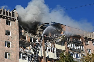Firefighters douse flames at a residential building damaged in a Russian drone strike on Kharkiv. AFP