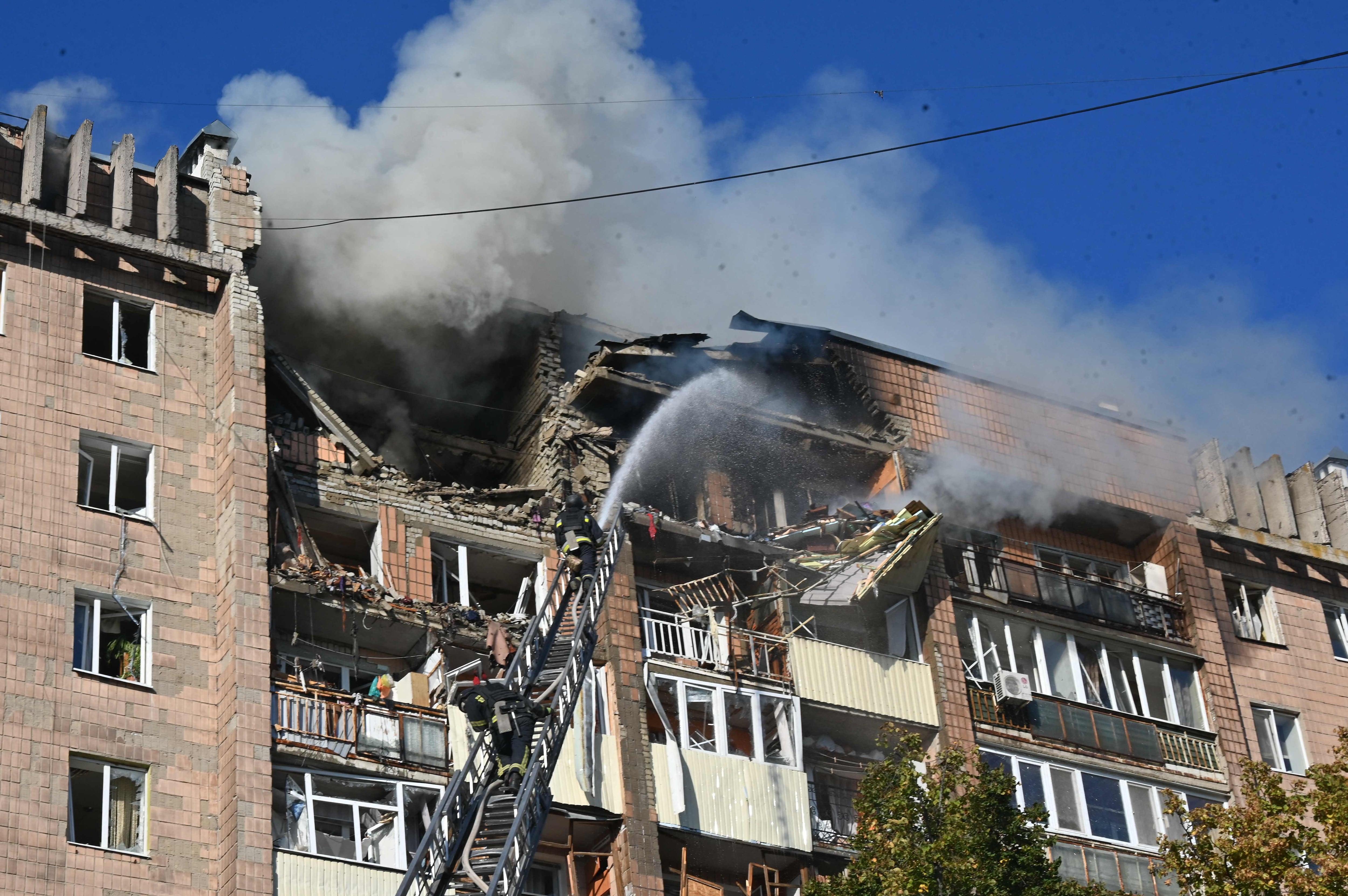 Firefighters douse flames at a residential building damaged in a Russian drone strike on Kharkiv. AFP