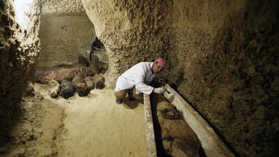 An archaeologist works on a mummy at the Tuna El-Gebel archaeological site in Minya, Egypt. EPA