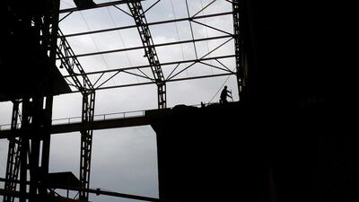 A worker shovels coal to power the big machines at the factory.