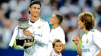 Real Madrid's Cristiano Ronaldo holds the trophy while celebrating with teammates after winning the Spanish Super Cup. Francisco Seco / AP Photo