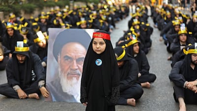 Supporters of the Lebanese Shiite Hezbollah movement hold a picture of Iran's late supreme leader Ayatollah Ruhollah Khomeini, as they take part in a religious mourning procession on the tenth day of the lunar month of Muharram, which marks the day of Ashura, in a suburb of the capital Beirut. AFP