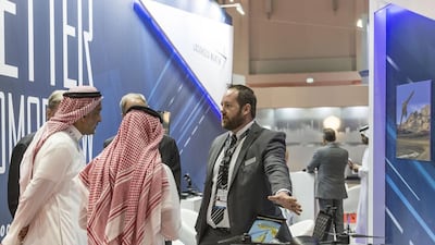 Visitors listen as a Lockheed Martin staff explains the company's products and technologies on display at UMEX 2016.