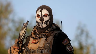 A masked Iraqi special forces soldier stands on top of a vehicle in Mosul, Iraq.