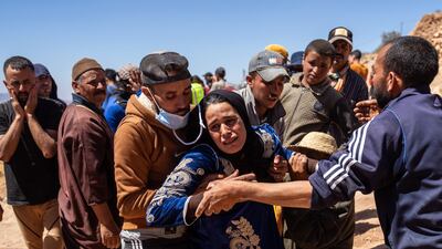 A woman is overcome with grief as the body of her husband is removed from beneath a collapsed house in Douzrou. Getty Images