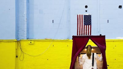 A woman enters a voting booth at a polling site in a school gym to cast a vote in the US presidential primary in Hoboken, New Jersey. New Jersey, California, and four other states held presidential primaries on Tuesday. Justin Lane / EPA