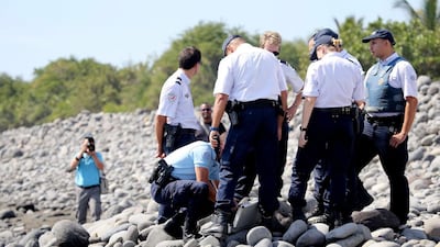 Police officers comb a beach on Reunion Island looking for debris on August 2, 2015, after a part of Boeing 777 aircraft washed ashore last week. Richard Bouhet / AFP Photo