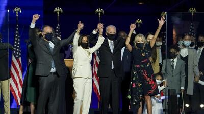 US president-elect Joe Biden, wife Jill Biden, vice president-elect Kamala Harris and husband Douglas Emhoff hold hands while wearing protective masks during a post-election event in Wilmington, Delaware. Bloomberg