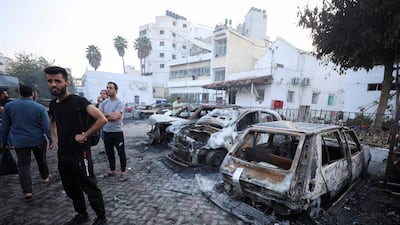 People inspect the area around Al Ahli Arab Hospital, where hundreds of Palestinians were killed in a blast that Israeli and Palestinian officials blamed on each other. Reuters