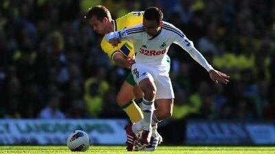 Norwich City, in yellow, and Swansea City are under pressure to remain in the top flight. Jamie McDonald / Getty Images