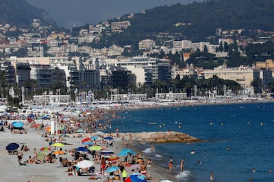People enjoy the sun on a beach of the Promenade des Anglais in Nice, southern France. EPA