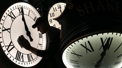 Dave LeMote wipes down a post clock at Electric Time Company Inc in Medfield, United States. Most Americans will set their clocks 60 minutes forward before heading to bed on Saturday night, but daylight saving time officially starts Sunday at 2am local time. (Elise Amendola / AP Photo / March 7, 2014)