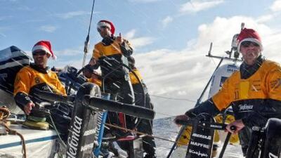 Telefonica crew members, from left, Jordi Calafat, skipper Iker Martinez and Neal McDonald, get in the festive spirit in the sun and spray.