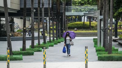 A pedestrian wearing a protective mask walks along a near-deserted road in Bonifacio Global City, Metro Manila. Bloomberg