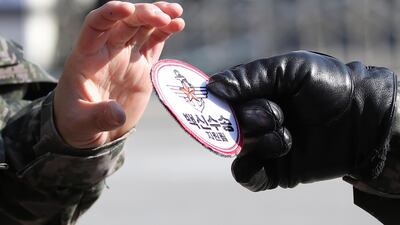 A military officer hands a 'vaccine transportation' patch to a colleague during a joint rehearsal by police and the army for the transportation of COVID-19 vaccines at the National Medical Center in Seoul, South Korea. South Korea will begin its vaccination drive in February. EPA