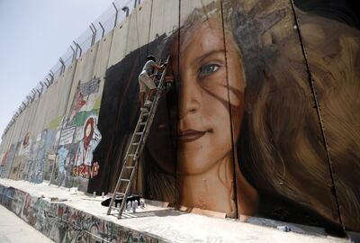 An Italian artist paints a mural of Palestinian Ahed Tamimi on the Israeli separation wall in the West Bank city of Bethlehem. EPA