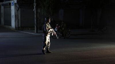 An Afghan police man stand guard outside the wedding hall after an explosion in Kabul, Afghanistan. AP