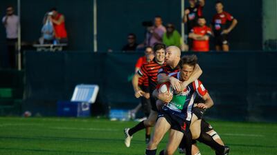 Ryno Fourie of the Jebel Ali Dragons, seen here getting tackled by Matt Hutchings of the Abu Dhabi Saracens, was among the tries against Doha on Friday. Victor Besa for The National