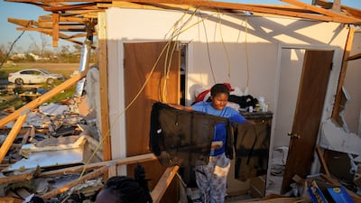 A teenager affected by the Mississippi tornado sorts his belongings. Reuters