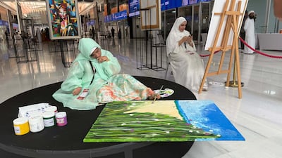 Moza Abdullah creates art at the event in Sharjah. Ali Al Shouk / The National
