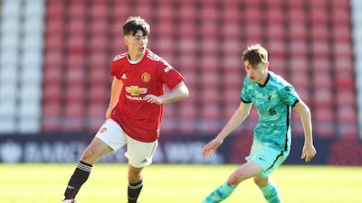 Manchester United's Charlie McNeill runs with the ball under pressure from Conor Bradley of Liverpool. Getty Images