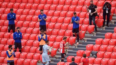 Athletic Bilbao's Iker Muniain Koke of Atletico Madrid lay flowers in the stand in memory of the victims of Covid-19. Getty